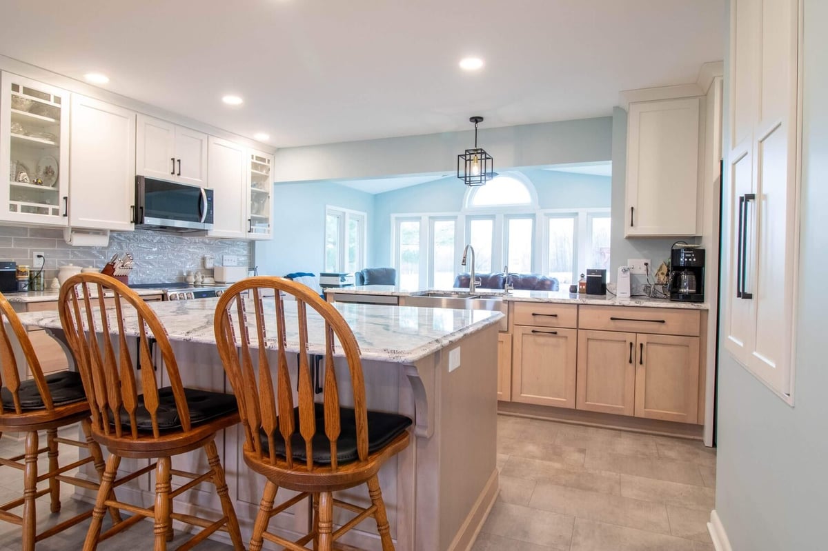 remodeled kitchen island by Odd Fellows Contracting in Owosso, MI with waterfall quartz countertop