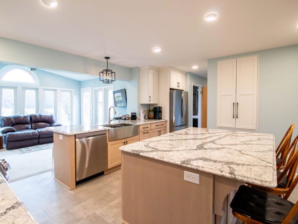 wide view of remodeled kitchen by Odd Fellows Contracting in Owosso, MI with island seating and quartz counters