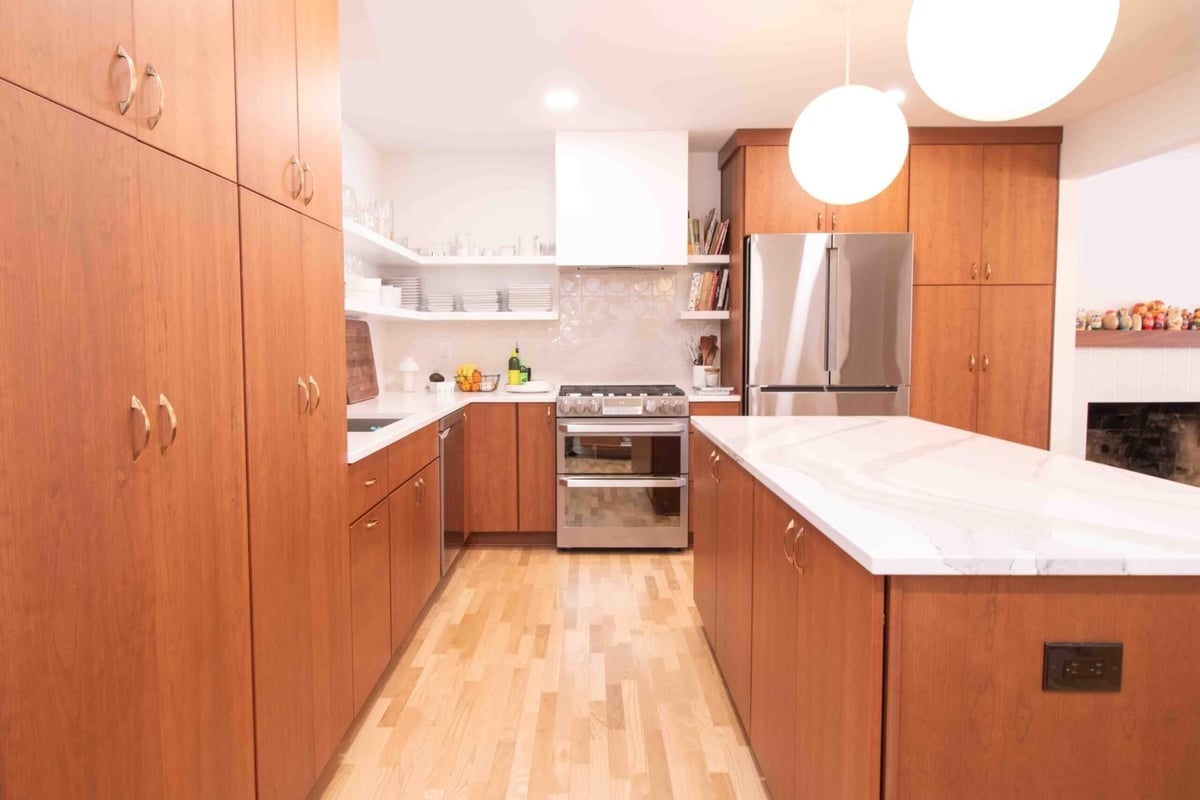 bright kitchen remodel by Odd Fellows Contracting in East Lansing, MI with large island and stainless steel appliances