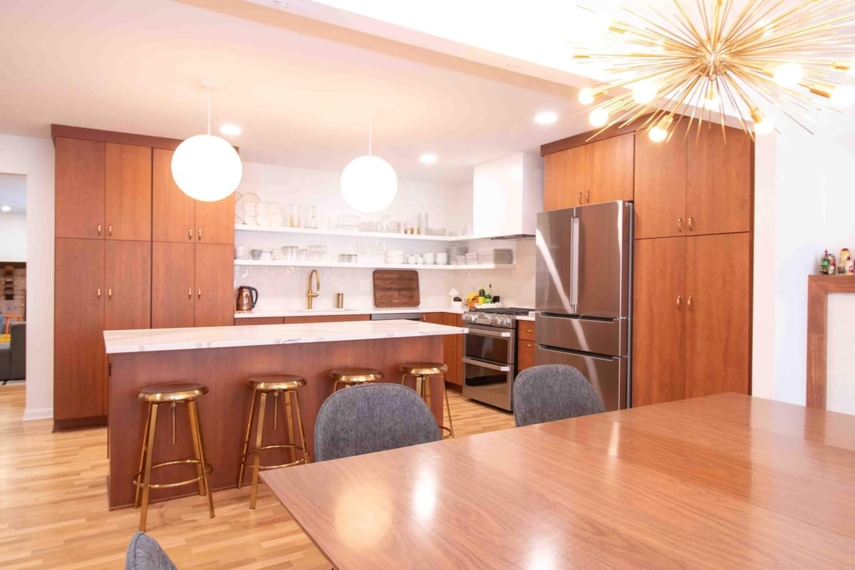 modern kitchen remodel by Odd Fellows Contracting in East Lansing, MI with walnut cabinets and white island