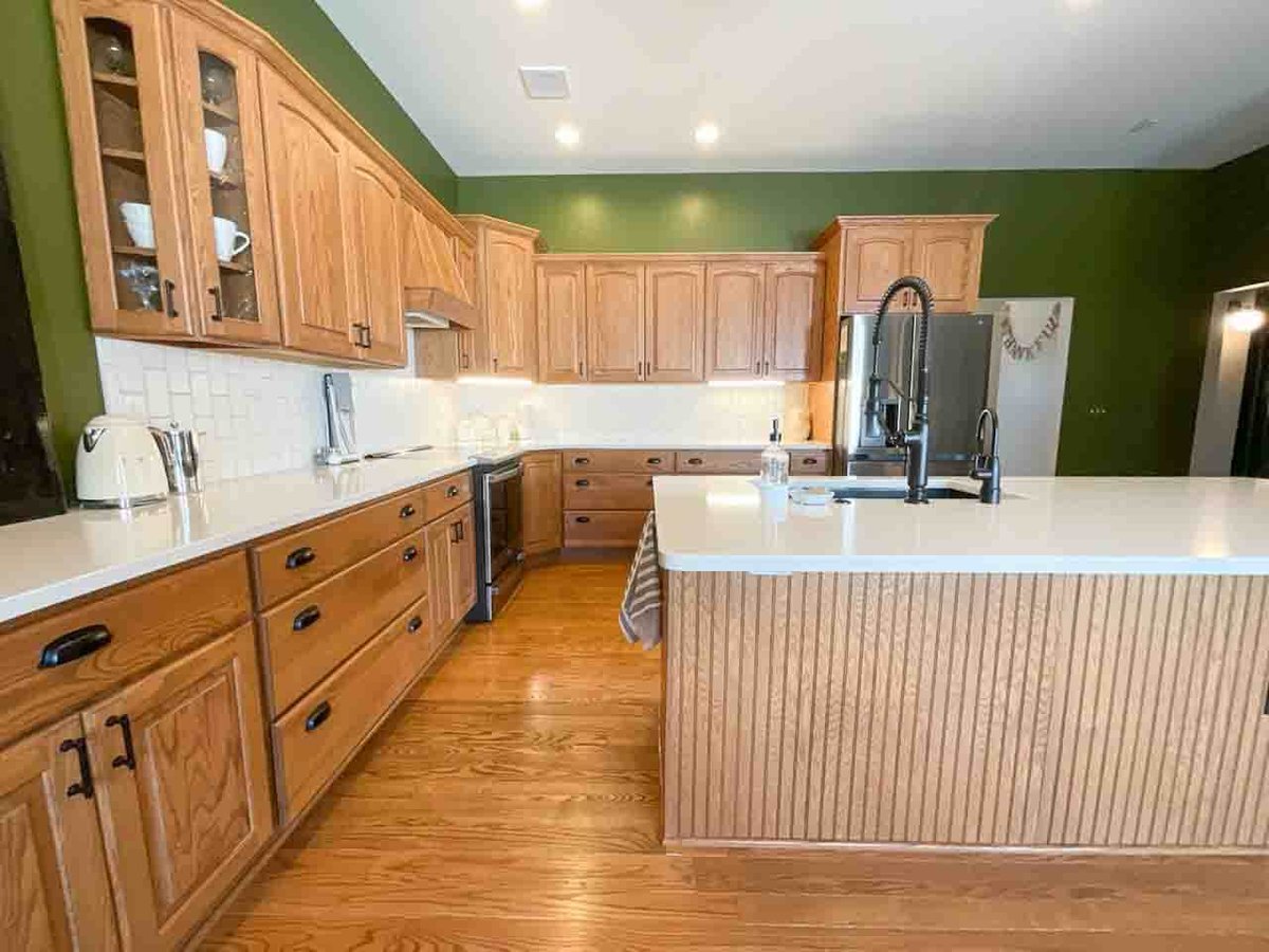renovated kitchen featuring quartz countertops and wood cabinets by Odd Fellows Contracting in Dewitt MI
