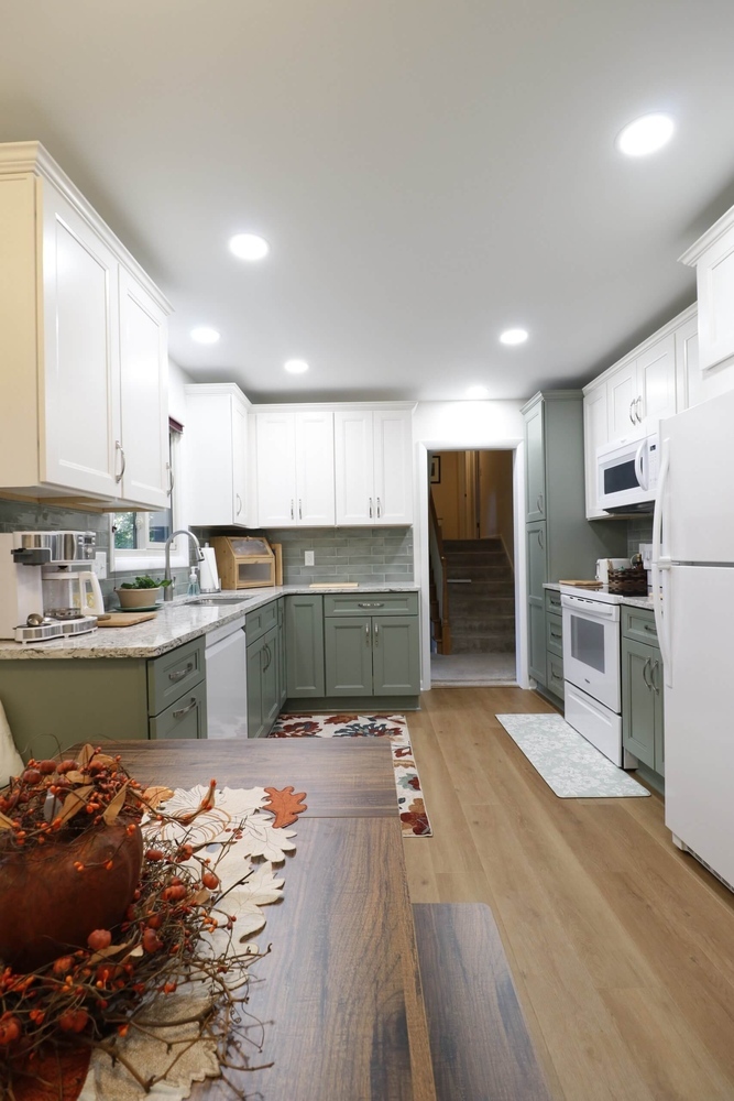 kitchen renovation by Odd Fellows Contracting in Tacoma Hills, MI showcasing white upper cabinets and green lowers