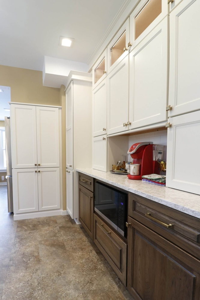 Lansing Westside MI kitchen remodel by Odd Fellows Contracting featuring white upper cabinets and wood base cabinets