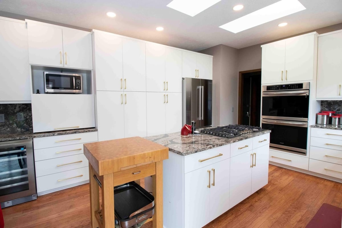 kitchen remodel featuring island cooktop modern cabinetry and recessed lighting by Odd Fellows Contracting in Lansing MI