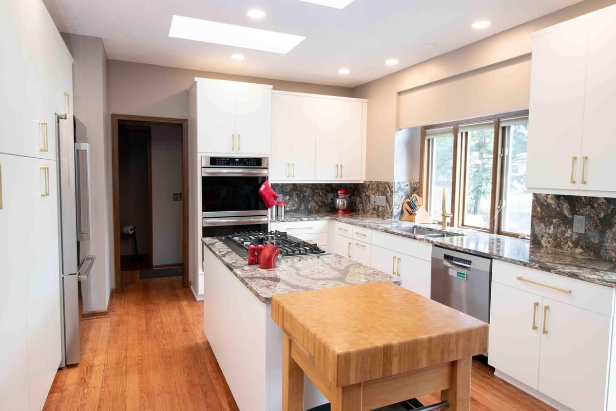 kitchen remodel featuring modern cabinetry recessed lighting and island workspace by Odd Fellows Contracting in Lansing MI