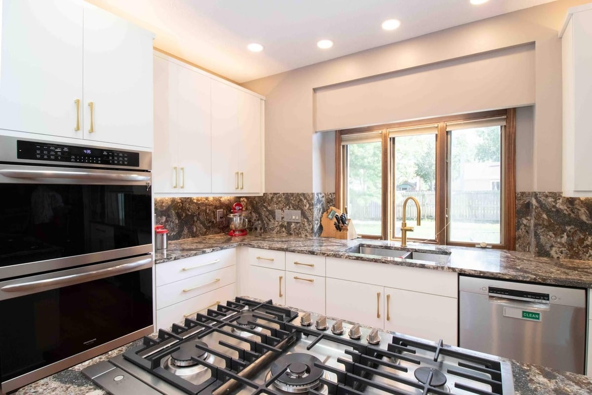 remodeled kitchen with island cooktop granite countertops and custom cabinets by Odd Fellows Contracting in Lansing MI