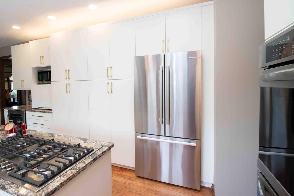remodeled kitchen with tall pantry cabinets and stainless steel refrigerator by Odd Fellows Contracting in Lansing MI