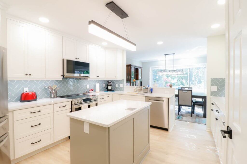 bright kitchen remodel in Emerald Lake, MI by Odd Fellows Contracting featuring quartz island and stainless appliances