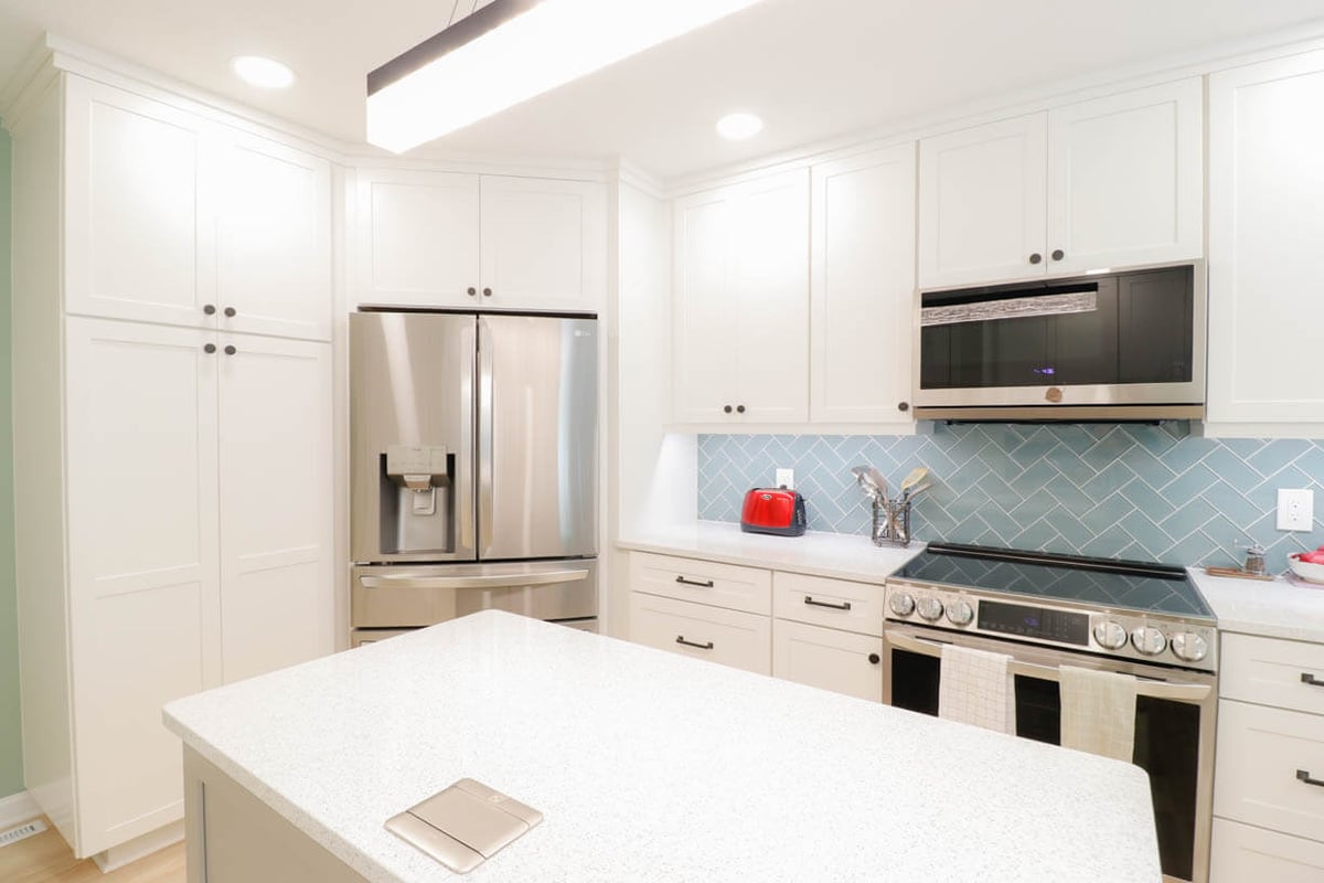 completed kitchen remodel by Odd Fellows Contracting in Emerald Lake, MI with stainless fridge and modern range
