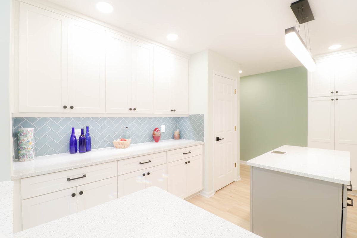 finished kitchen remodel by Odd Fellows Contracting in Emerald Lake, MI with built in cabinetry and blue backsplash