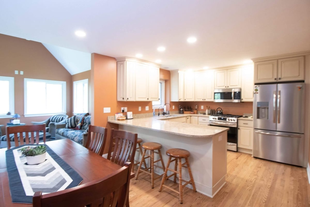 remodeled kitchen with white cabinets and peninsula seating by Odd Fellows Contracting in Williamston MI