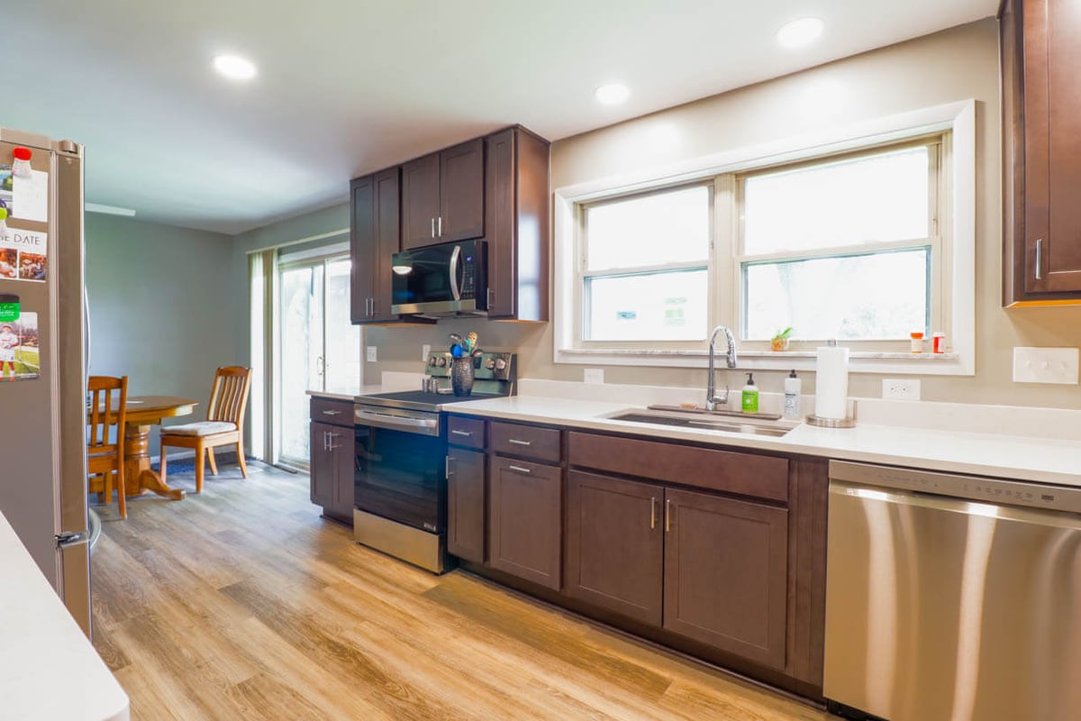 Finished kitchen remodel by Odd Fellows Contracting in St. Joe, MI featuring dark wood cabinetry, quartz countertops, and stainless steel appliances.