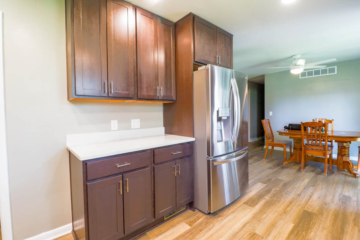 Kitchen remodel detail by Odd Fellows Contracting in St. Joe, MI with tall pantry cabinets and stainless refrigerator.