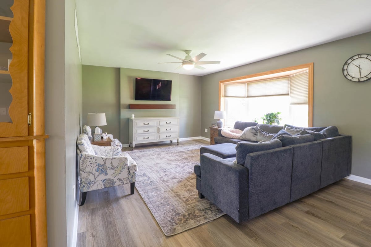 Open-concept living room update connected to kitchen remodel by Odd Fellows Contracting in St. Joe, MI with new flooring and paint.