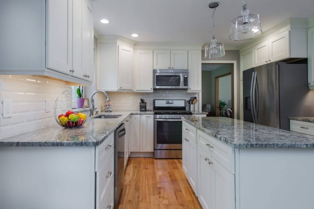 Galley kitchen remodel with white cabinets and granite countertops in Okemos MI by Odd Fellows Contracting