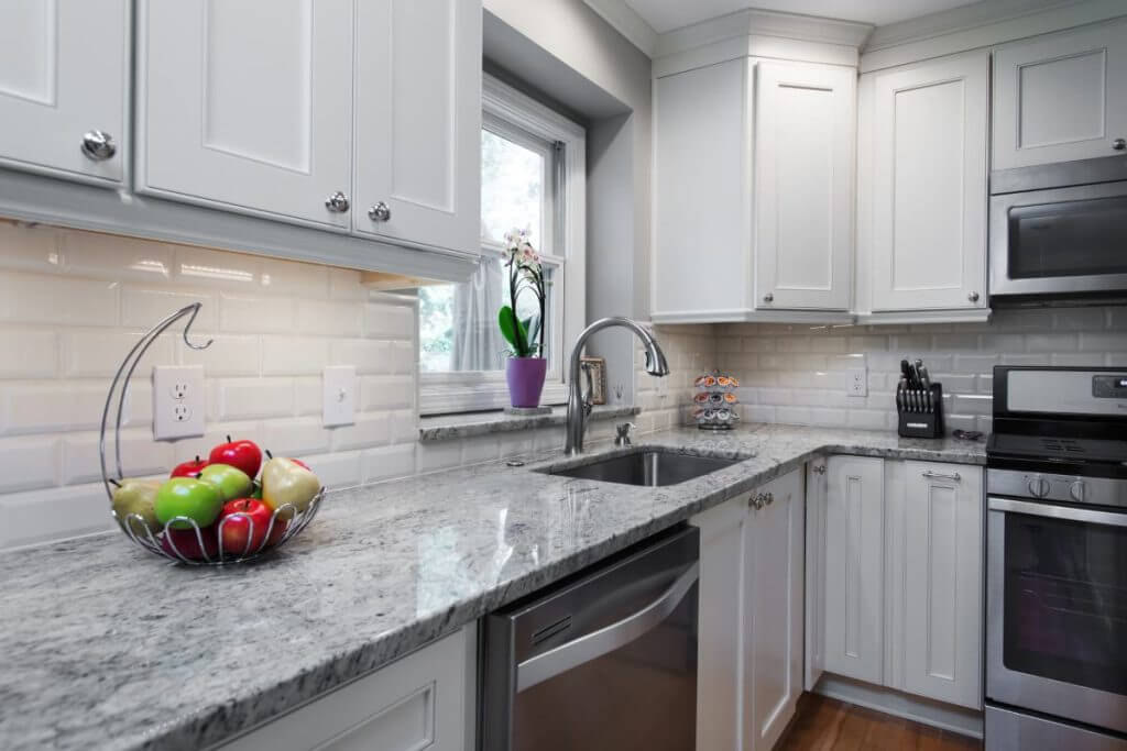 Granite countertop with undermount sink and subway tile backsplash in Okemos MI by Odd Fellows Contracting