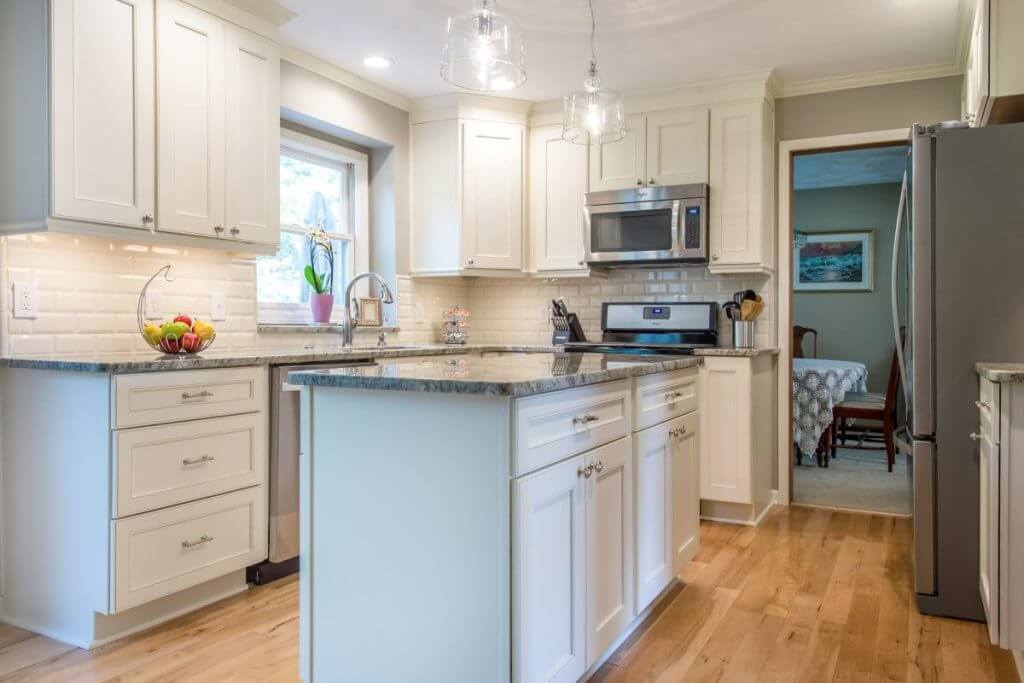 Kitchen remodel with white cabinets and granite island in Okemos MI by Odd Fellows Contracting