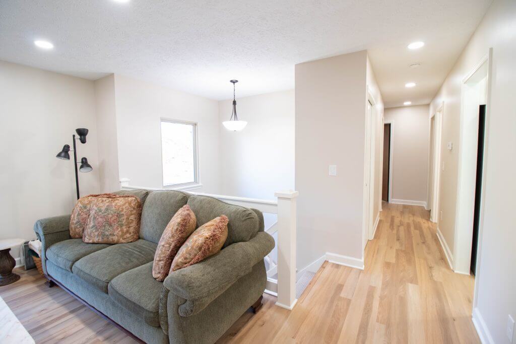 Interior remodel showing updated living space with modern flooring and lighting by Odd Fellows Contracting in Lansing, MI.