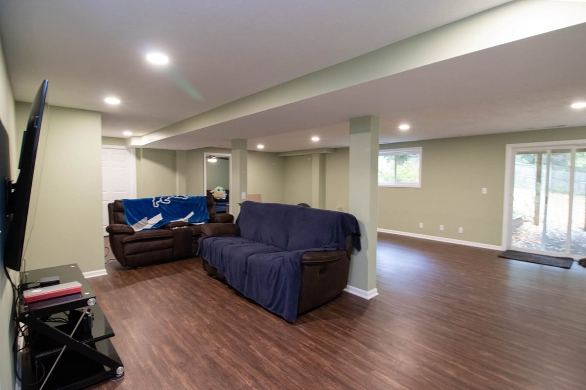 Finished basement remodel with seating area and open layout by Odd Fellows Contracting in Lansing, MI.