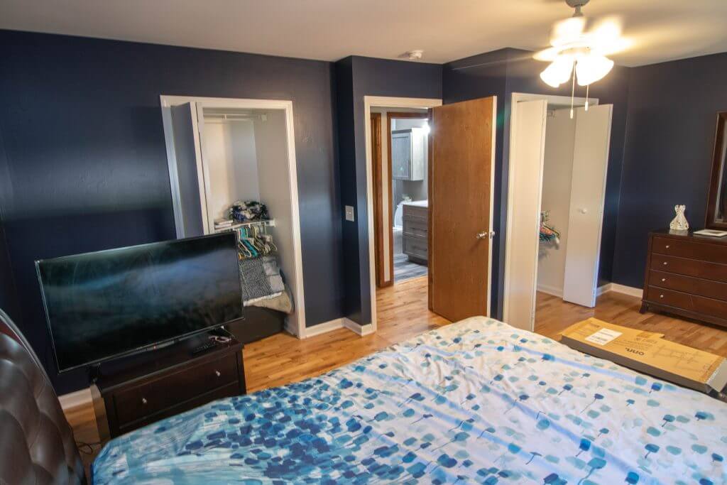 bedroom before remodel with hardwood floors, dresser, and wall mirror by Odd Fellows Contracting in Holt, MI