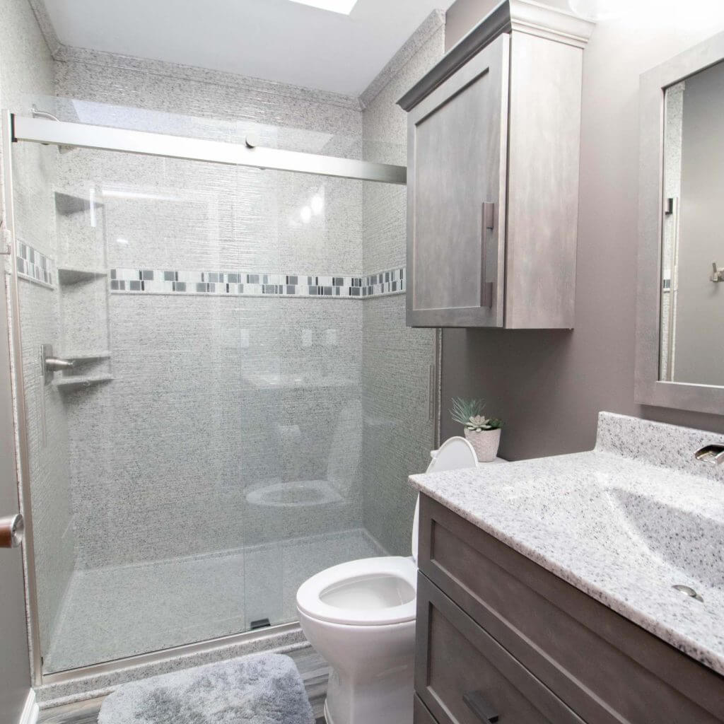 finished bathroom remodel with quartz vanity and glass shower by Odd Fellows Contracting in Holt, MI