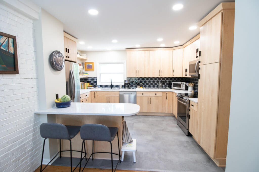 Modern kitchen renovation with quartz countertops and tile backsplash by Odd Fellows Contracting in East Lansing, MI