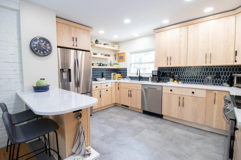 Open concept kitchen renovation with peninsula and custom cabinets by Odd Fellows Contracting in East Lansing, MI