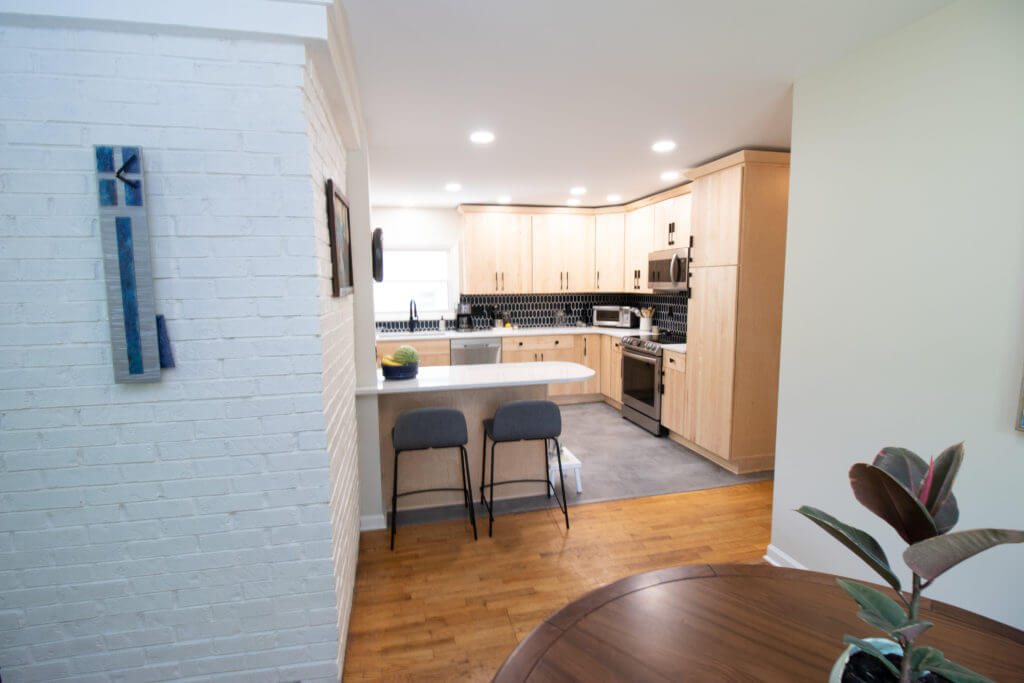 Open kitchen remodel with peninsula seating and custom cabinets by Odd Fellows Contracting in East Lansing, MI