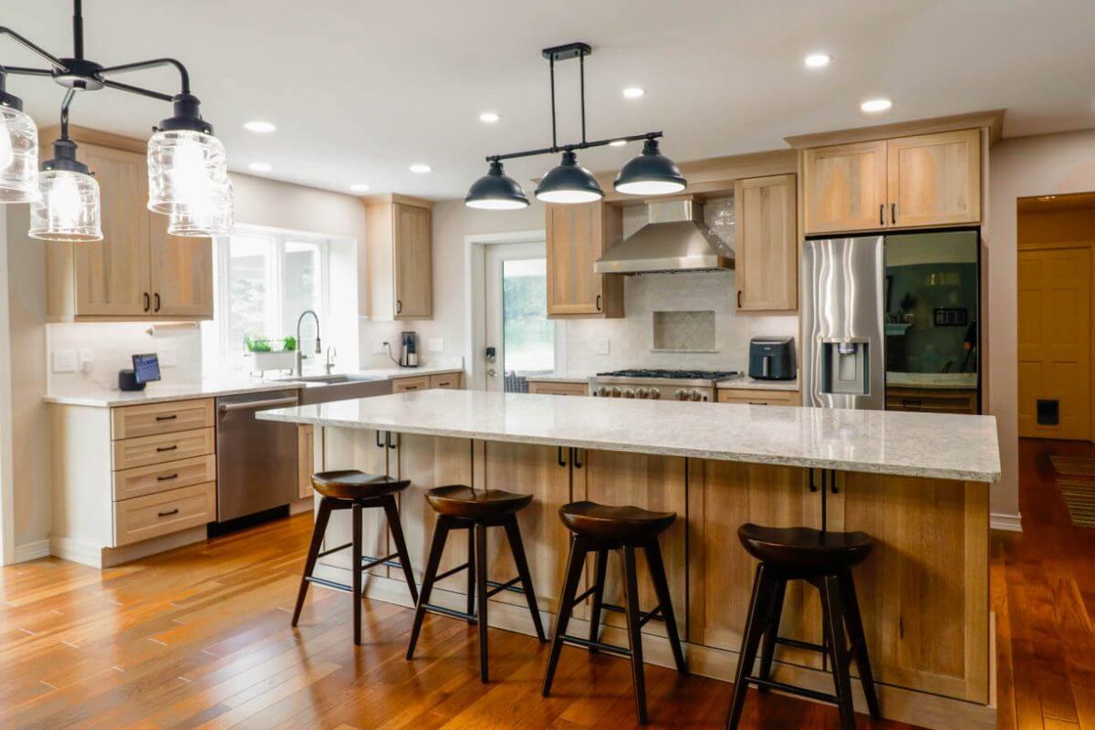 Custom home kitchen in Cornell Woods, MI built by Odd Fellows Contracting with large quartz island and wood cabinetry.