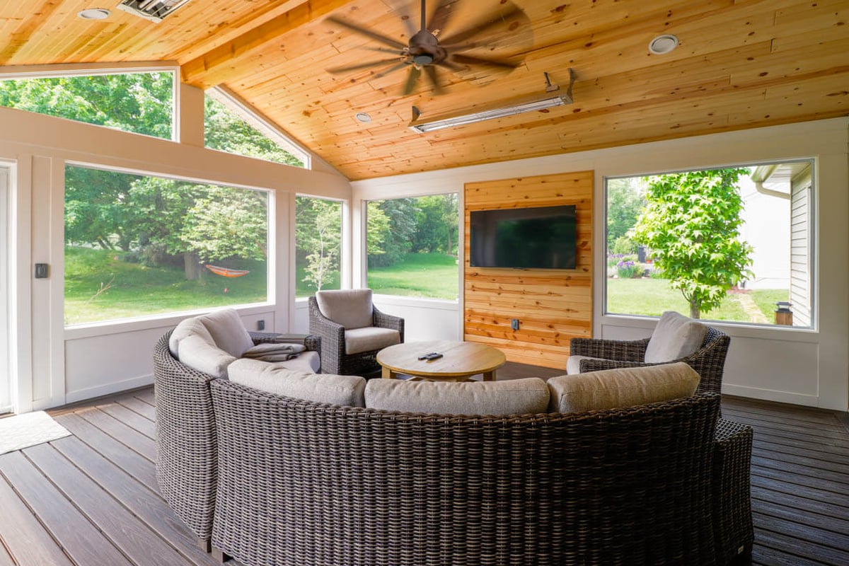 Screened porch addition on custom home by Odd Fellows Contracting in Cornell Woods, MI with wood ceiling and outdoor seating.