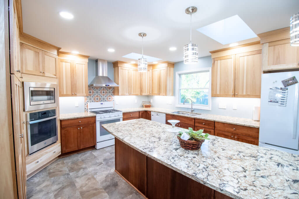 modern kitchen renovation with granite island countertop and custom cabinets by Odd Fellows Contracting in Grand Ledge, MI