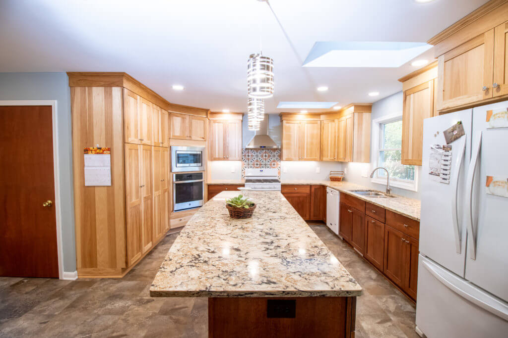 remodeled kitchen with granite island, wood cabinetry, and skylights by Odd Fellows Contracting in Grand Ledge, MI