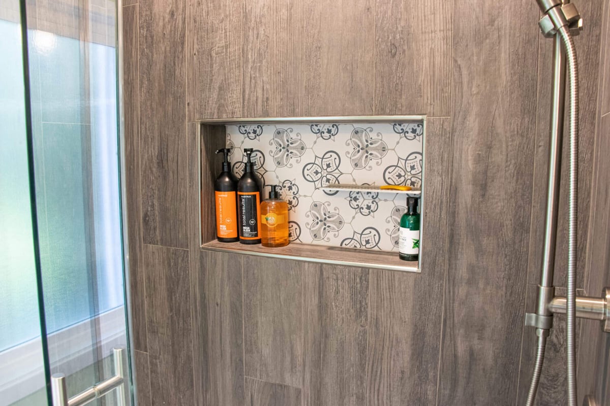 custom shower shelving by Odd Fellows Contracting in Williamston MI with patterned tile accent