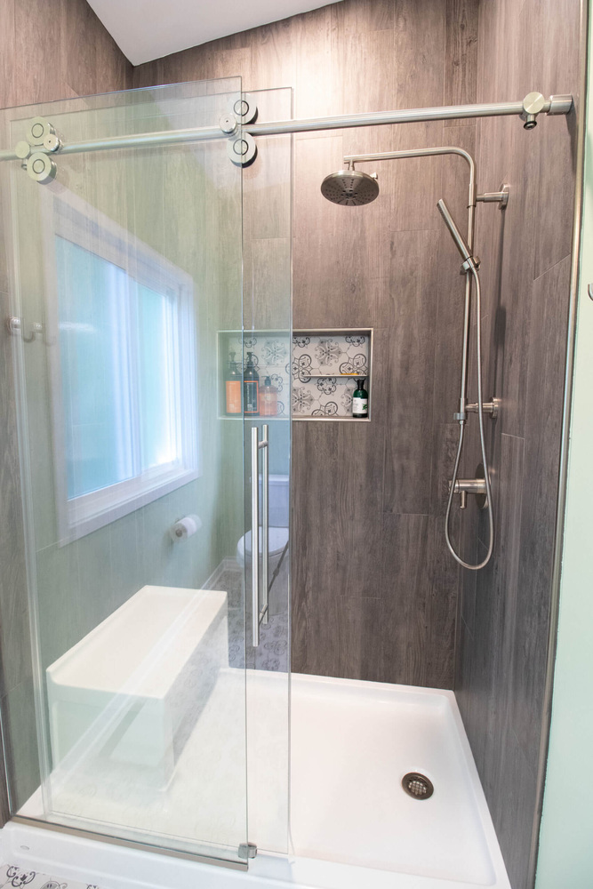 walk-in shower remodel by Odd Fellows Contracting in Williamston MI with glass door and tiled walls
