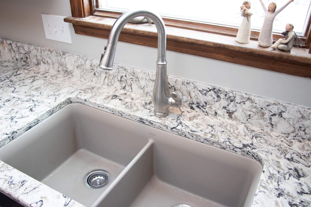 kitchen remodel detail by Odd Fellows Contracting in Mason MI with farmhouse sink and quartz countertops