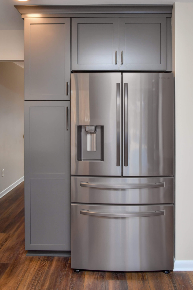 Kitchen appliance wall with built-in microwave and gray cabinets from remodel by Odd Fellows Contracting in Okemos, MI