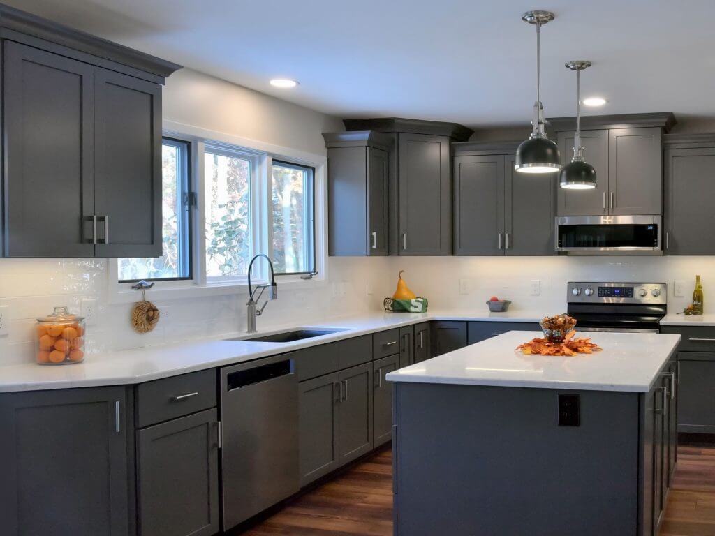 Remodeled kitchen with gray cabinets, white countertops, and center island by Odd Fellows Contracting in Okemos, MI