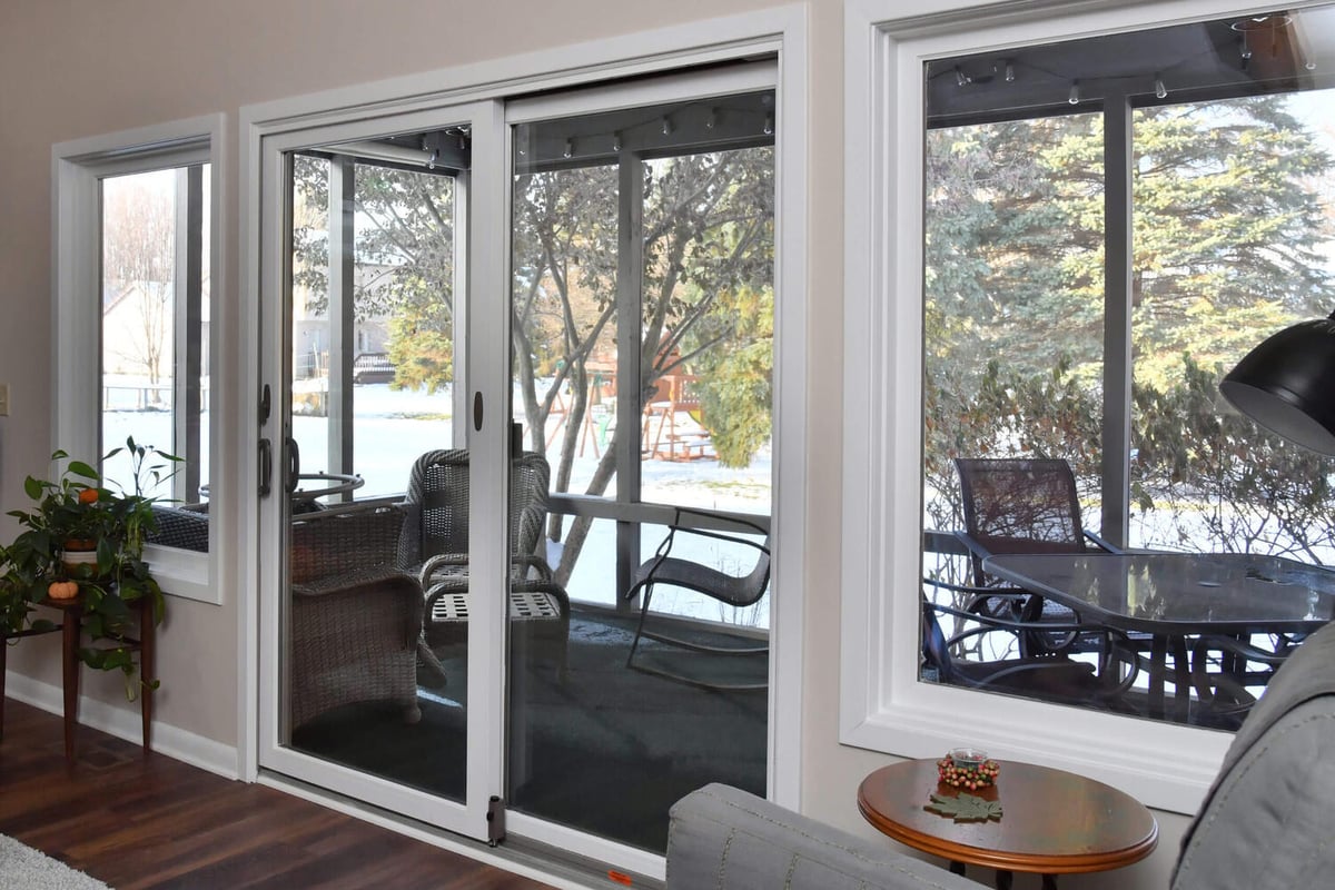 Updated family room with sliding patio doors and outdoor backyard view from remodel by Odd Fellows Contracting in Okemos, MI