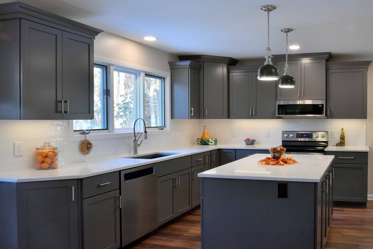 Updated kitchen renovation with quartz countertops and pendant lighting by Odd Fellows Contracting in Okemos, MI