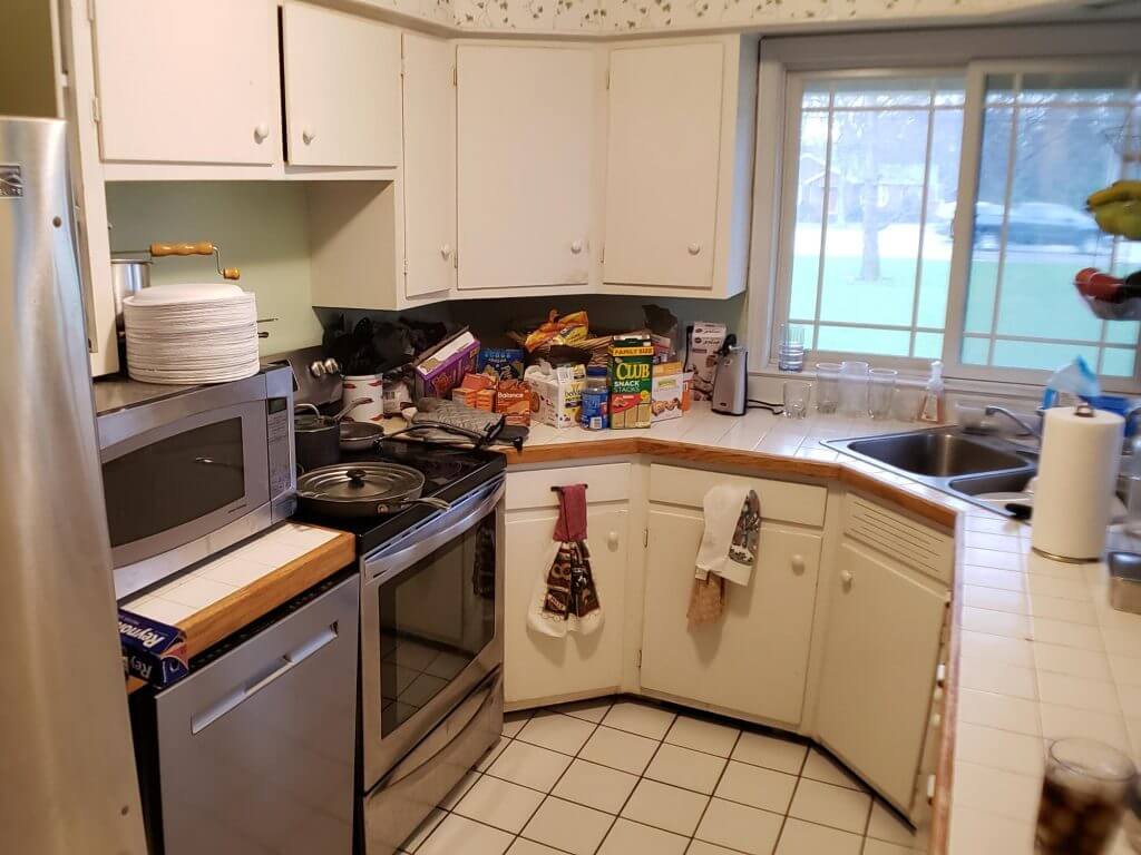bright kitchen renovation featuring quartz island seating and white cabinetry by Odd Fellows Contracting in Lansing, MI