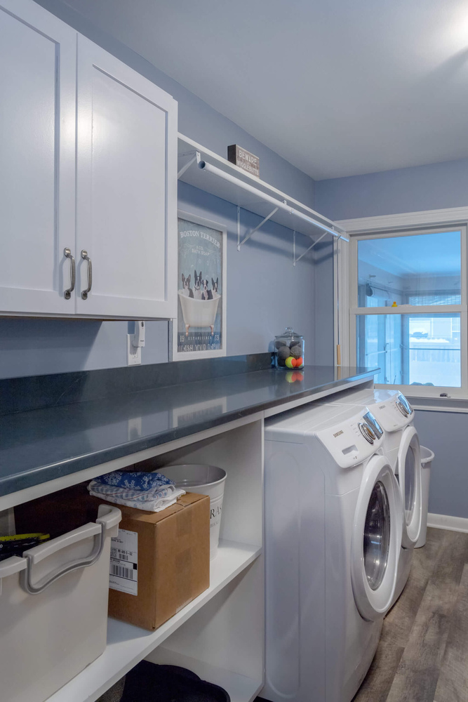 laundry room remodel featuring washer and dryer with countertop workspace by Odd Fellows Contracting in Lansing, MI