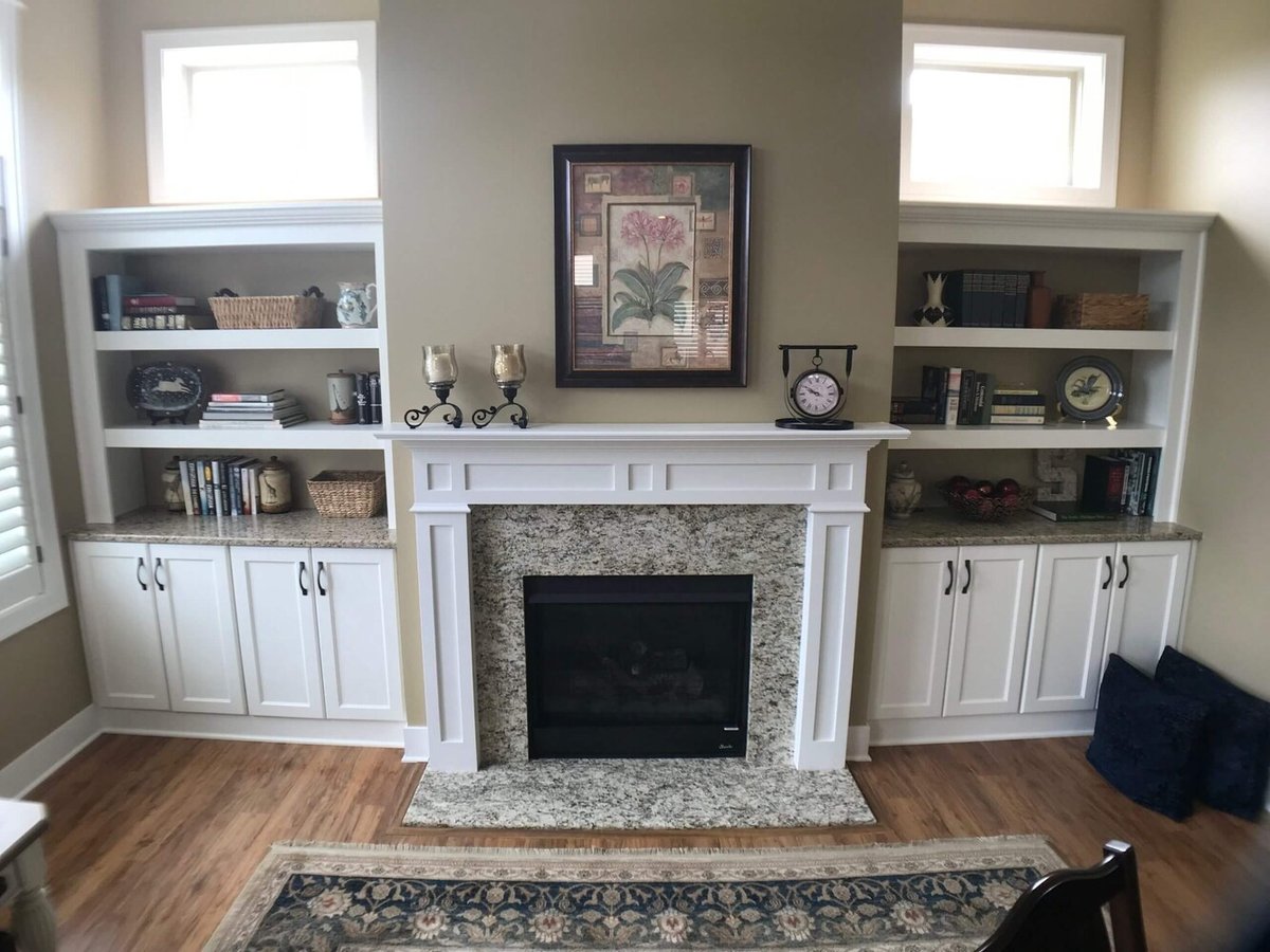 custom fireplace wall with built in shelving and cabinets by Odd Fellows Contracting in Holt, MI