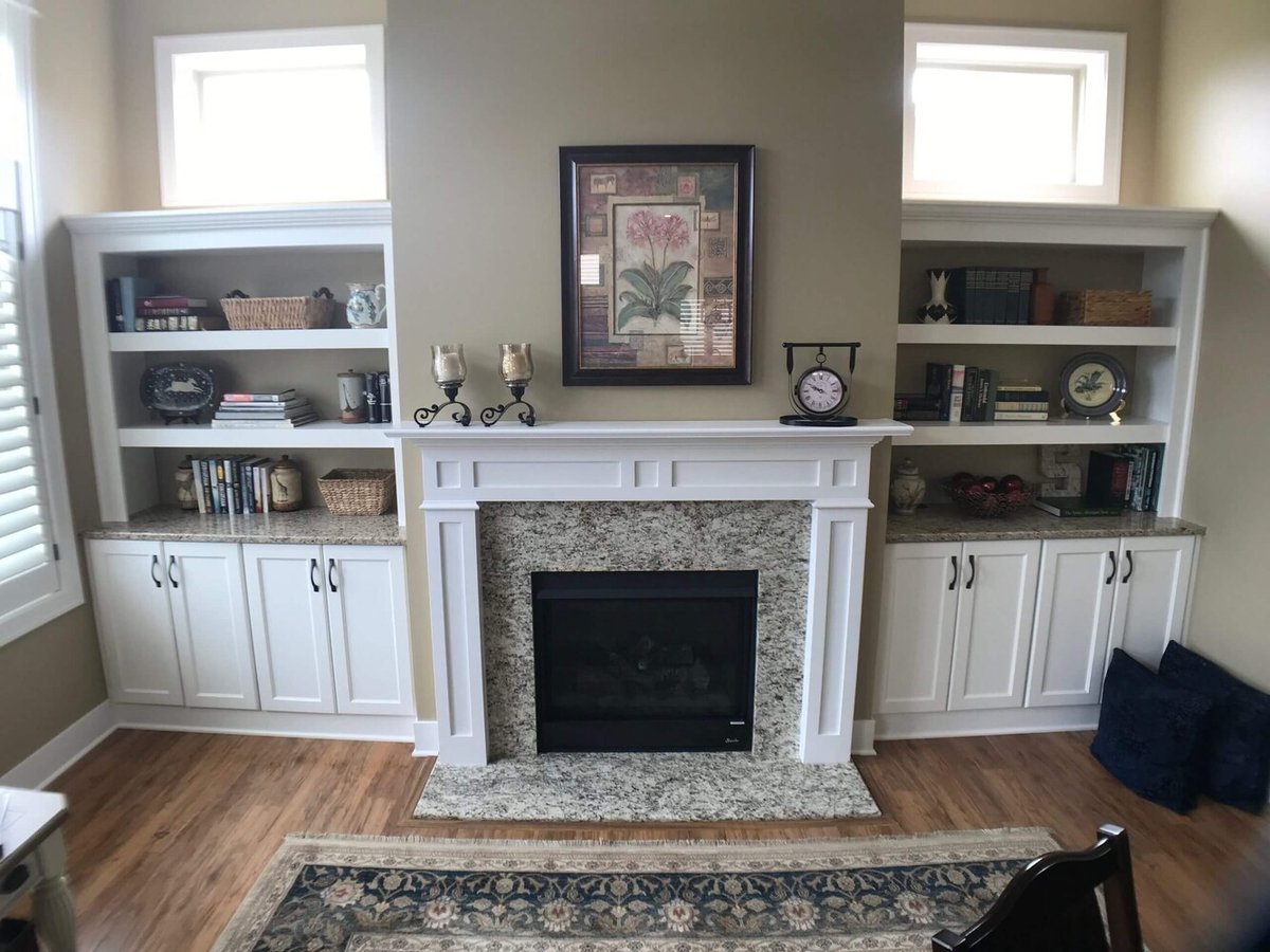 finished fireplace wall with built in cabinets and shelving by Odd Fellows Contracting in Holt, MI