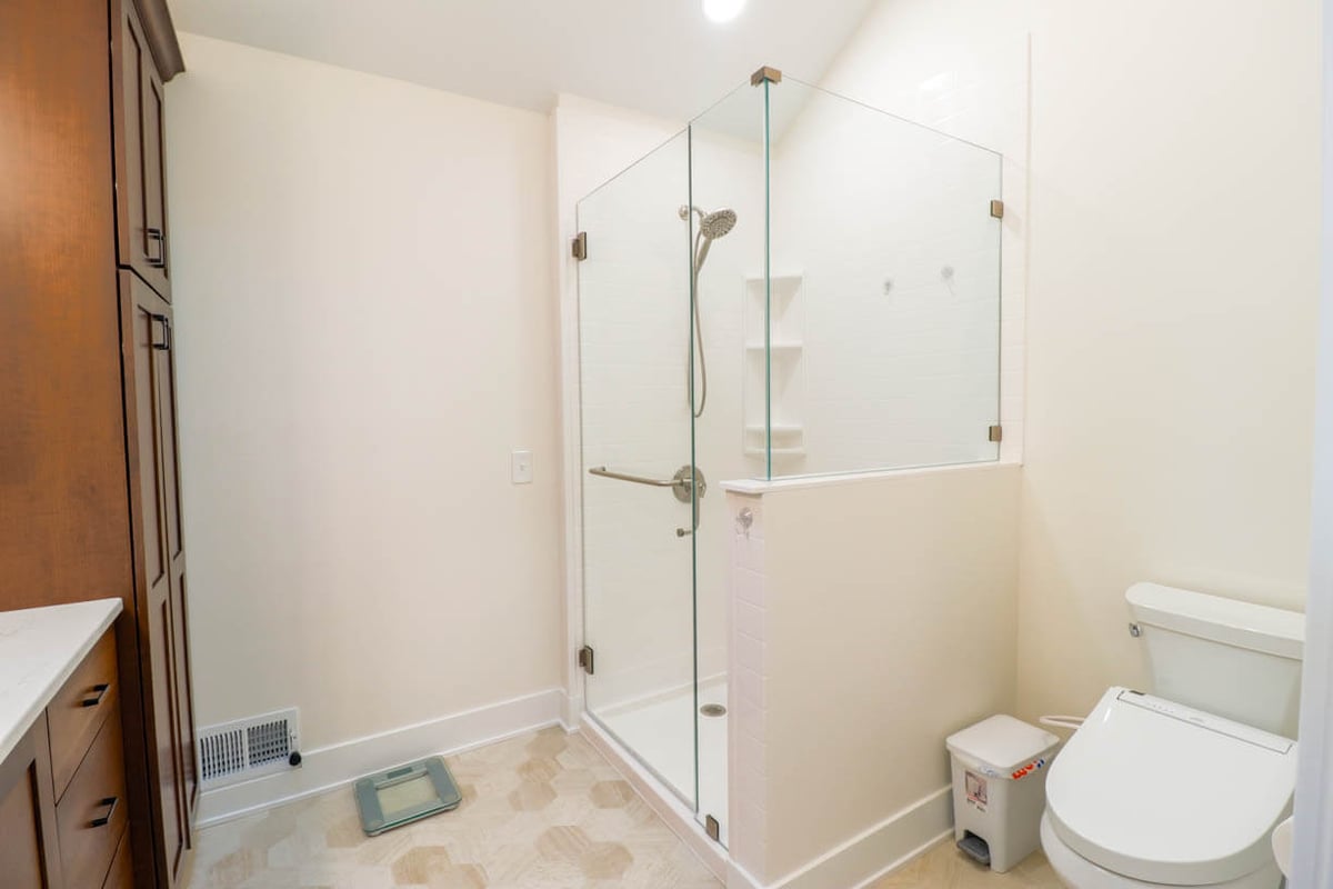 custom home bathroom remodel by Odd Fellows Contracting in Lansing, MI with glass corner shower and tile flooring