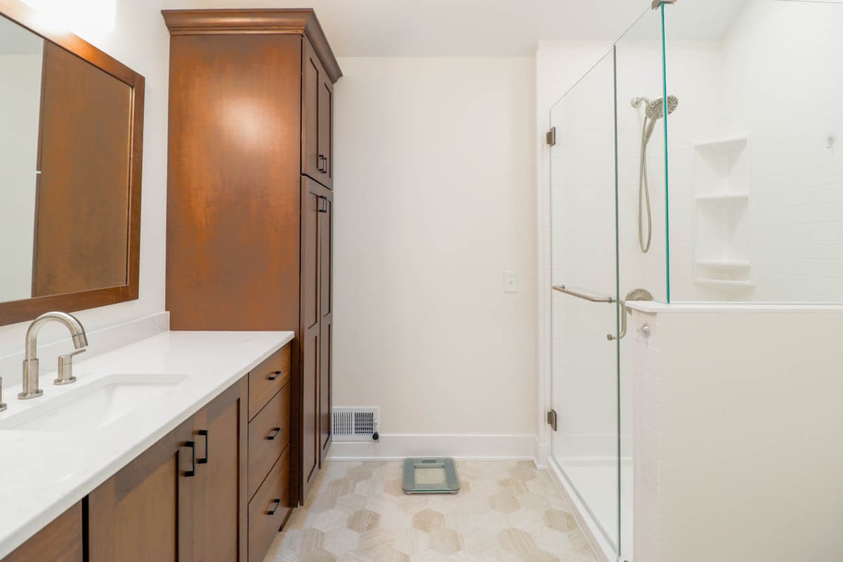 custom home bathroom renovation by Odd Fellows Contracting in Lansing, MI featuring wood cabinetry and quartz counter