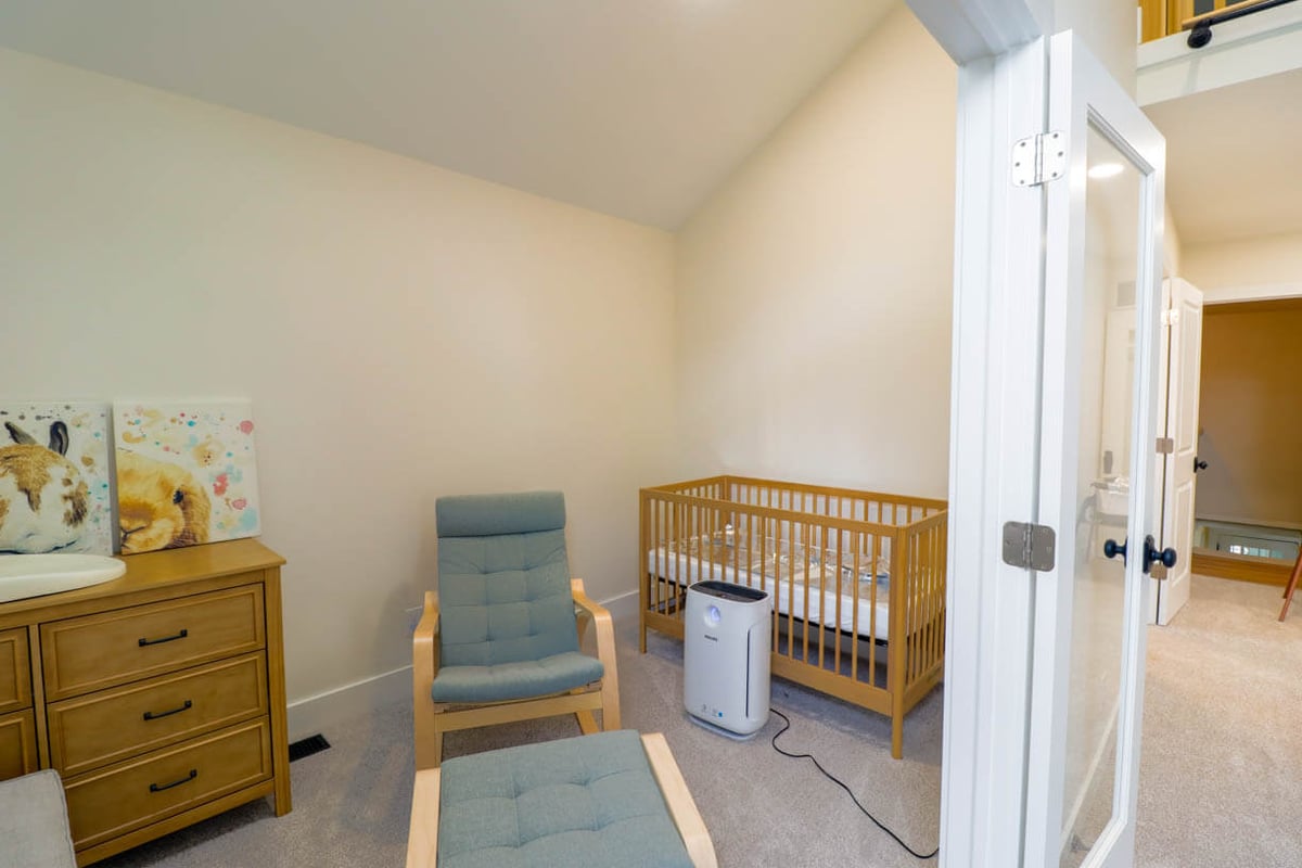 custom home nursery addition by Odd Fellows Contracting in Lansing, MI with crib and rocking chair
