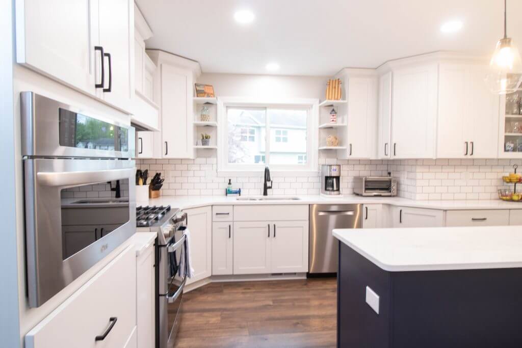 remodeled kitchen with large island and white quartz countertops by Odd Fellows Contracting in Cumberland Lansing MI