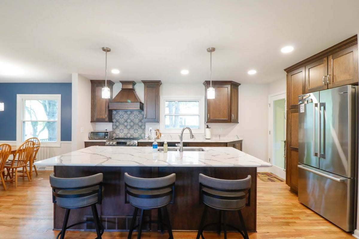 custom home kitchen by Odd Fellows Contracting in Cornell Okemos, MI featuring large quartz island and wood cabinetry