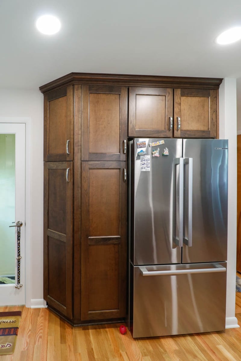 custom home kitchen pantry cabinets by Odd Fellows Contracting in Cornell Okemos, MI with built in refrigerator