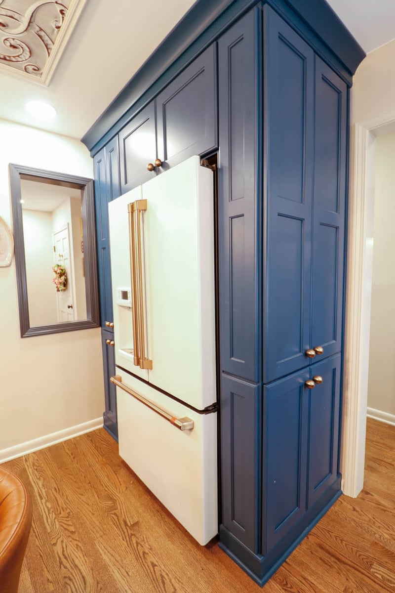 Built-in refrigerator with custom blue cabinetry in a Tacoma Hills, MI custom home by Odd Fellows Contracting.
